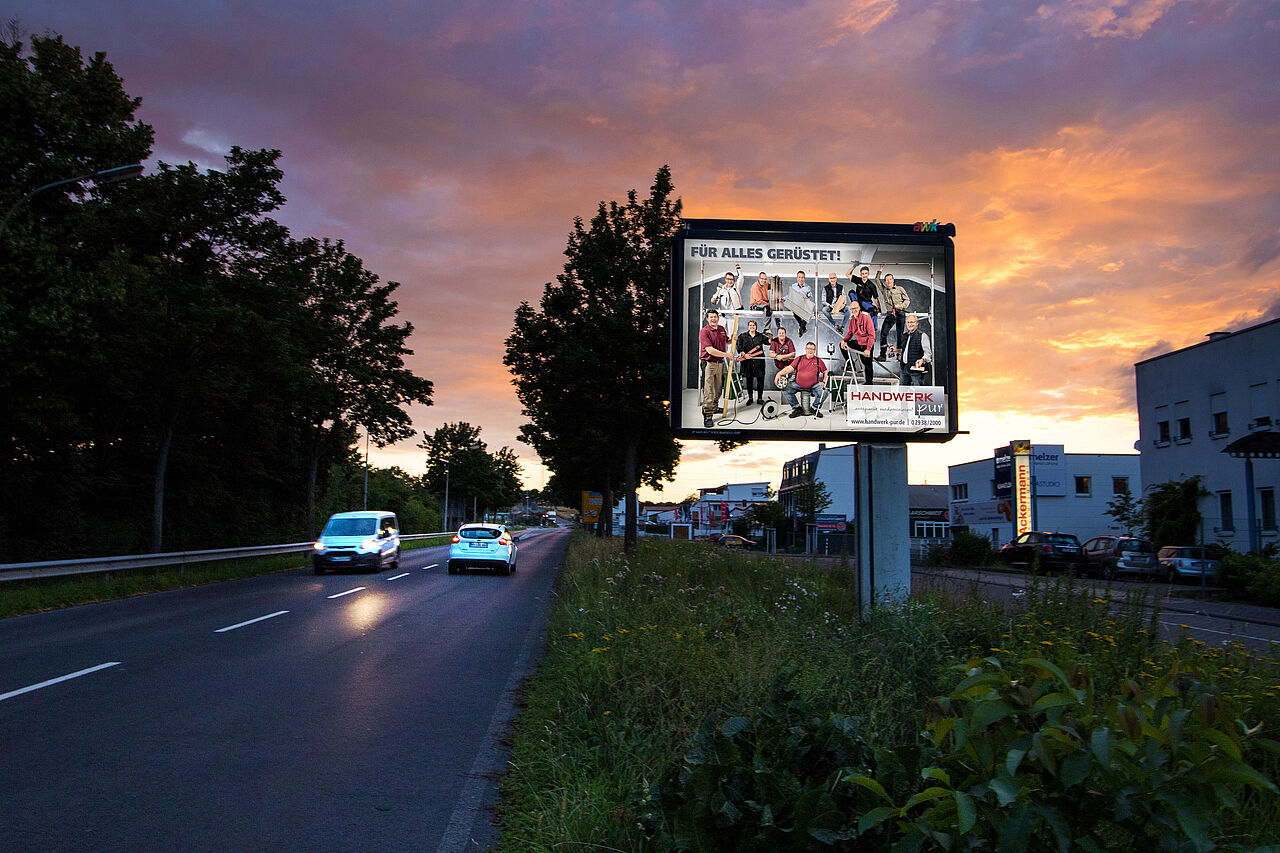 Großplakat mit 9 qm Werbefläche steht an befahrener Straße mit Handwerker-Motiv